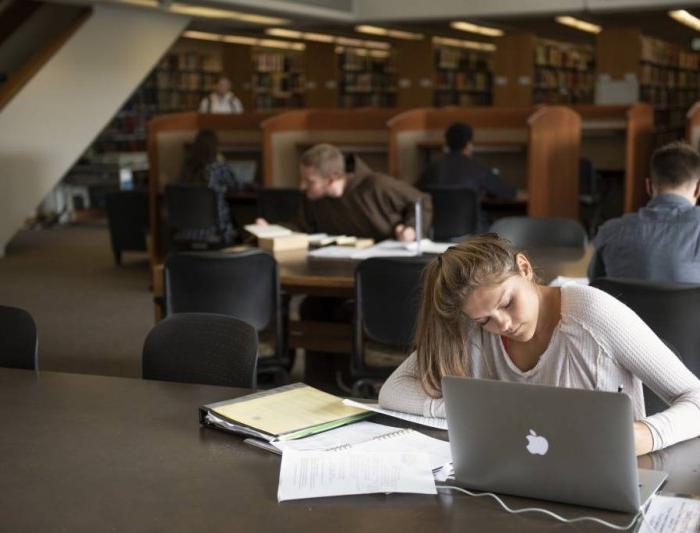 student writing in library