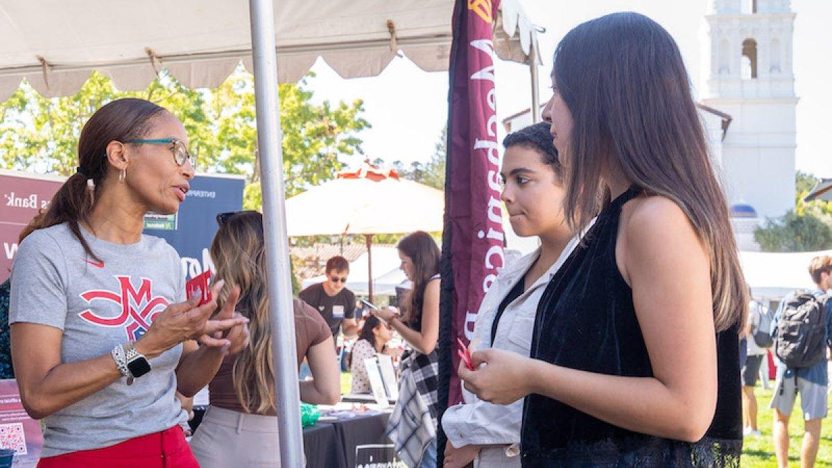 Two students talk with a recruiter at Career Fair